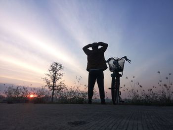 Low angle view of silhouette man photographing on street against sky