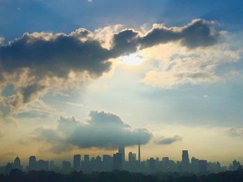 Skyscrapers in city against cloudy sky