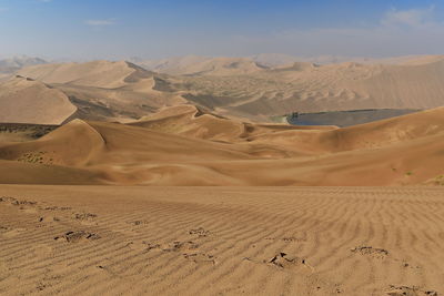 1180 sand megadunes overlook the s-w-e.shores of sumu barun jaran lake. badain jaran desert-china.