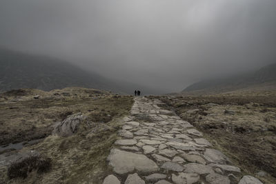 Rear view of person on mountain against sky