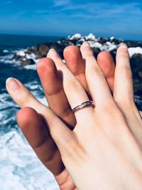 Close-up of couple holding hand at beach