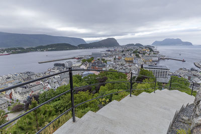 High angle view of city by mountains against sky