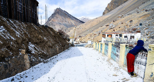 Rear view of people walking on snow covered mountain road