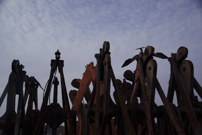 Low angle view of wooden posts against sky