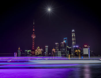 Illuminated buildings against sky at night