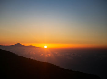 Scenic view of silhouette mountains against sky during sunset