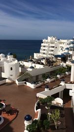 High angle view of town by sea against sky