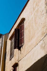 Mediterranean style urban building wooden jalousie in sunshine, blue sky