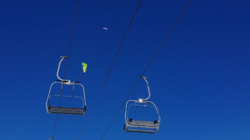 Low angle view of overhead cable car against blue sky