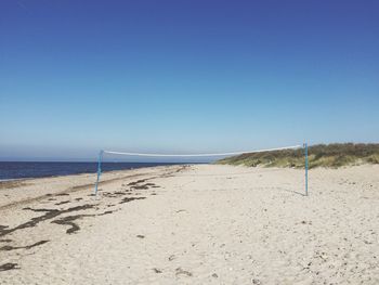 Scenic view of beach against clear blue sky