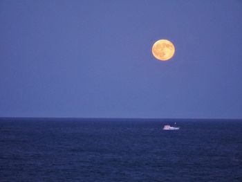 Scenic view of moon over calm blue sea