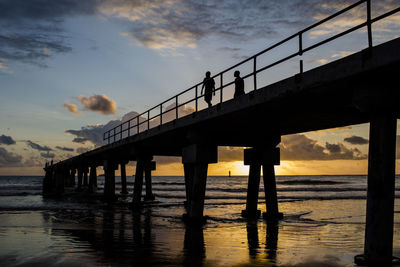 Bridge over sea against sky during sunset