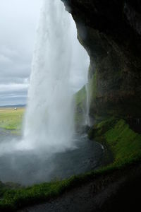 Scenic view of waterfall against sky