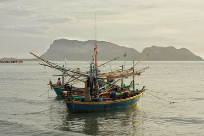 Fishing boat in sea against sky