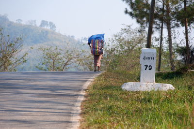 Rear view of a man walking on road