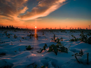 Scenic view of frozen lake against sky during sunset