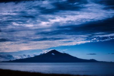 Scenic view of mountains against cloudy sky