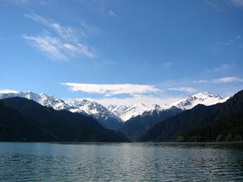 Scenic view of lake by snowcapped mountains against sky