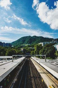 Railroad tracks by mountain against sky