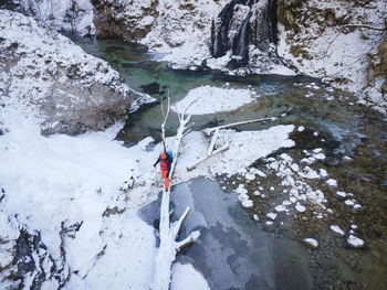 High angle view of man walking on fallen tree by river