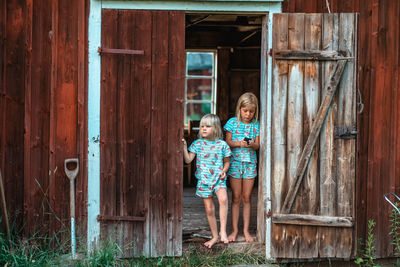 Full length of girl standing on wooden door