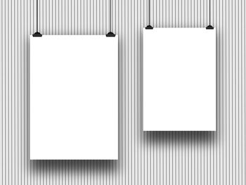 Close-up of empty white papers hanging against wall