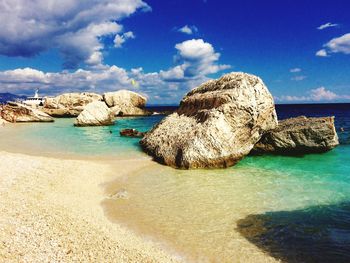 View of calm beach against blue sky