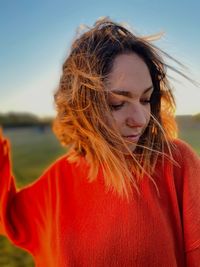 Portrait of beautiful young woman against sky