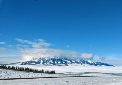 Scenic view of snowcapped mountains against blue sky