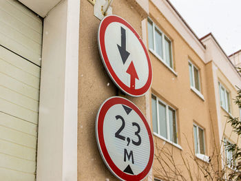 Low angle view of road sign on wall