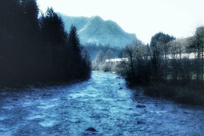 Scenic view of waterfall in forest against sky