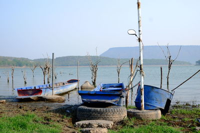 Boats moored on beach against clear sky