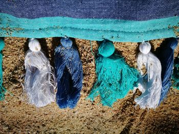 High angle view of fabric with tassels on sand