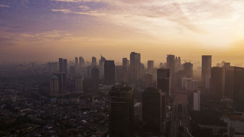 Aerial view of modern buildings against sky during sunset