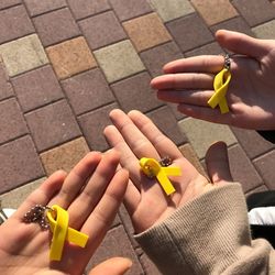Cropped hands holding yellow ribbons
