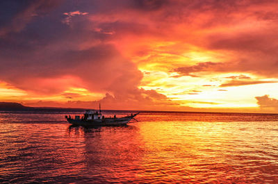 Scenic view of sea against dramatic sky during sunset