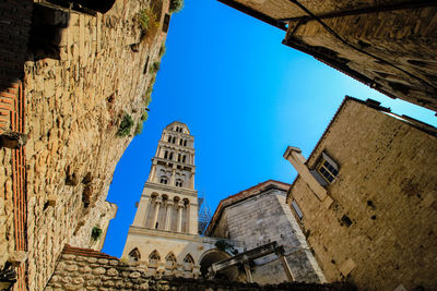 Low angle view of old building against clear blue sky