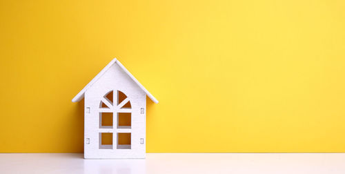 Close-up of yellow house against orange wall