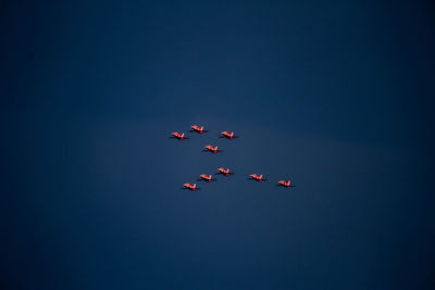 Low angle view of airshow against blue sky