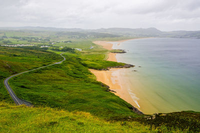 Scenic view of beach and sea against cloudy sky