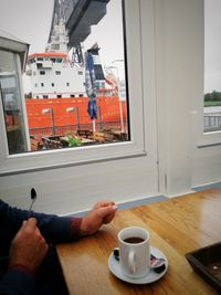 Man holding coffee cup on table