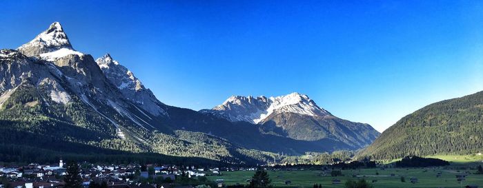 Scenic view of snowcapped mountains against blue sky