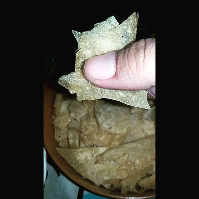 indoors, person, food and drink, food, part of, close-up, holding, cropped, black background, freshness, lifestyles, human finger, studio shot, still life, table, unrecognizable person