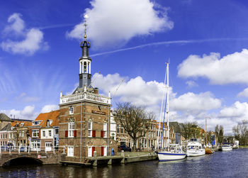 Boats moored in river against buildings