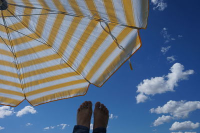 Cropped image of leg against blue sky