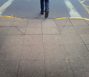Low section of man standing on road