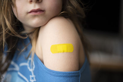 Midsection of girl with bandage on shoulder