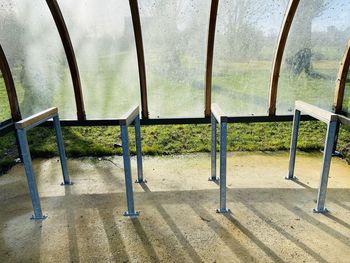 Empty seats on railing against trees