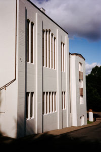 White building by road against sky