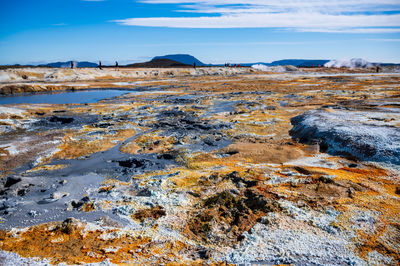 Scenic view of rocks on shore against sky